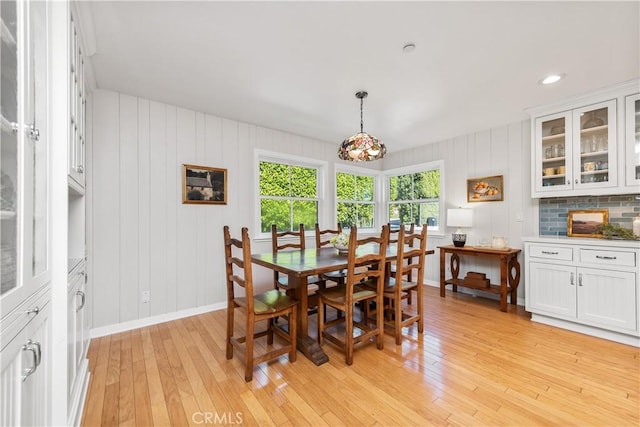 dining space with baseboards and light wood finished floors