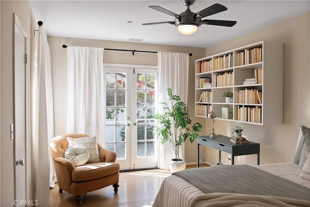 bedroom featuring french doors, wood finished floors, a ceiling fan, and access to exterior