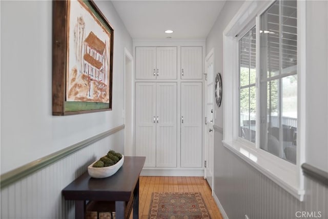 entryway with recessed lighting, a wainscoted wall, and light wood finished floors