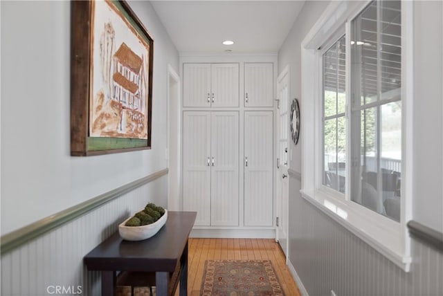 doorway to outside with a wainscoted wall, recessed lighting, and light wood-type flooring