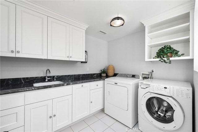 washroom with cabinet space, light tile patterned floors, visible vents, independent washer and dryer, and a sink