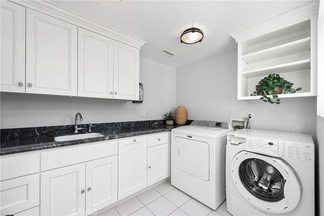 laundry area with visible vents, independent washer and dryer, a sink, cabinet space, and light tile patterned floors