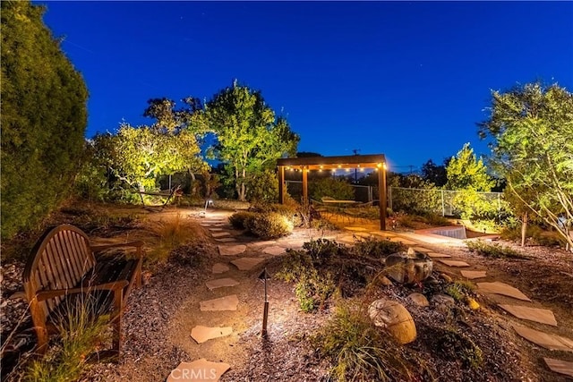 yard at night featuring fence