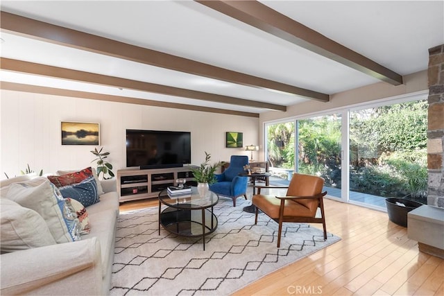 living area featuring beam ceiling and wood finished floors