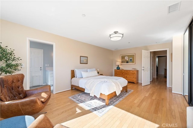 bedroom featuring light wood-style flooring, visible vents, and baseboards