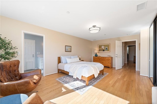 bedroom with baseboards, visible vents, and light wood-style flooring
