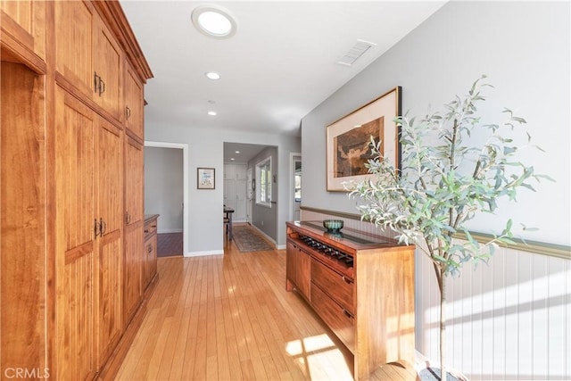 hall with recessed lighting, light wood-type flooring, visible vents, and baseboards