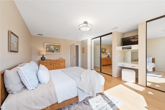 bedroom with visible vents and light wood-style floors