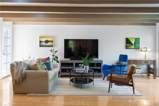 living area with wood finished floors and beam ceiling