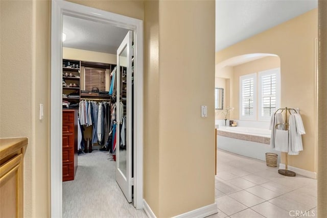 interior space with arched walkways and light tile patterned flooring