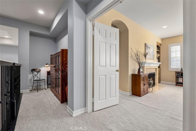 corridor featuring carpet, arched walkways, baseboards, and recessed lighting