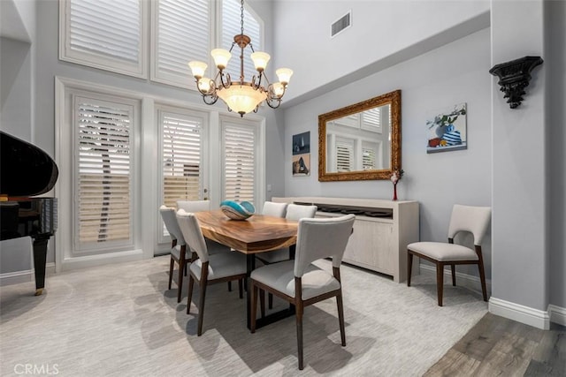 dining room with visible vents, a notable chandelier, and baseboards