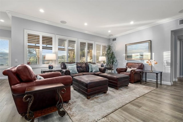 living area featuring ornamental molding, light wood-type flooring, visible vents, and baseboards