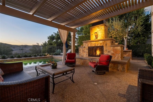 view of patio / terrace featuring an outdoor stone fireplace and fence