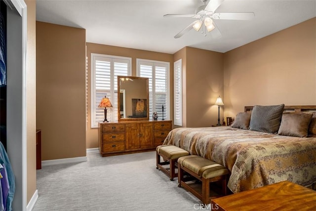 bedroom with a ceiling fan, light colored carpet, and baseboards