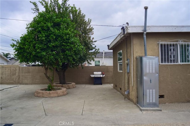 view of property exterior featuring a patio area, fence, and stucco siding