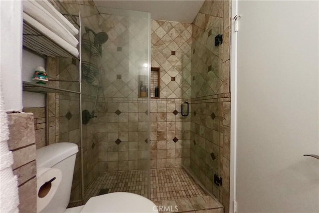 full bath featuring a shower stall and toilet