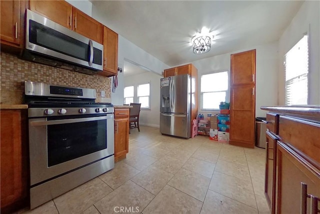 kitchen with appliances with stainless steel finishes, brown cabinetry, and decorative backsplash