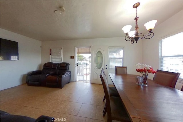 dining space with tile patterned floors and a notable chandelier