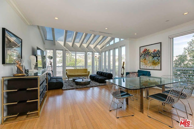 dining room with crown molding, light wood-style flooring, and a healthy amount of sunlight