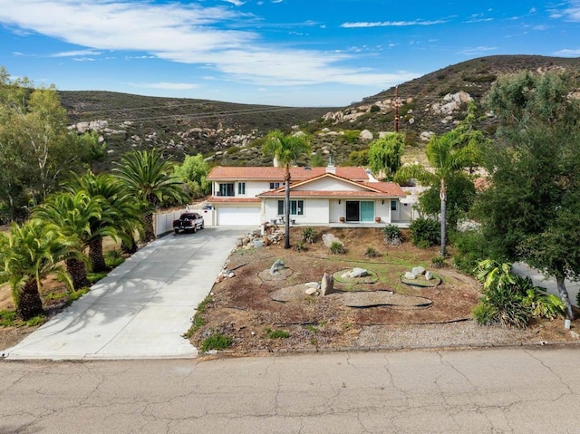 view of front facade featuring a mountain view, driveway, and a garage