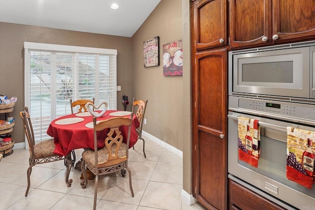 dining space with light tile patterned floors, baseboards, recessed lighting, and vaulted ceiling