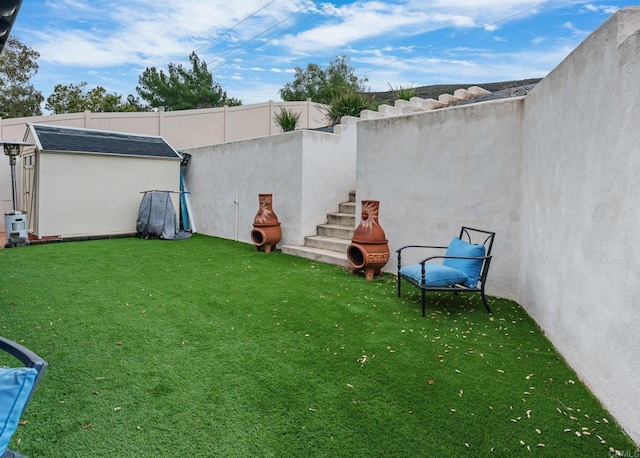 view of yard featuring an outdoor structure, fence, and a shed