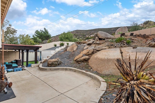 view of patio / terrace with a fenced backyard and a mountain view