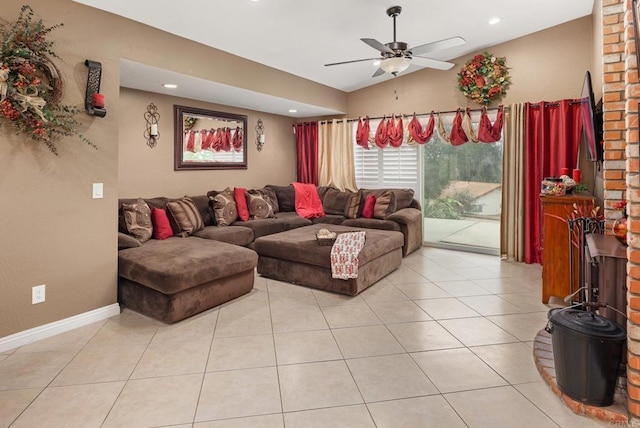 living area featuring baseboards, light tile patterned flooring, a ceiling fan, and vaulted ceiling