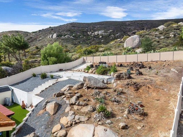 view of yard with a fenced backyard and a mountain view