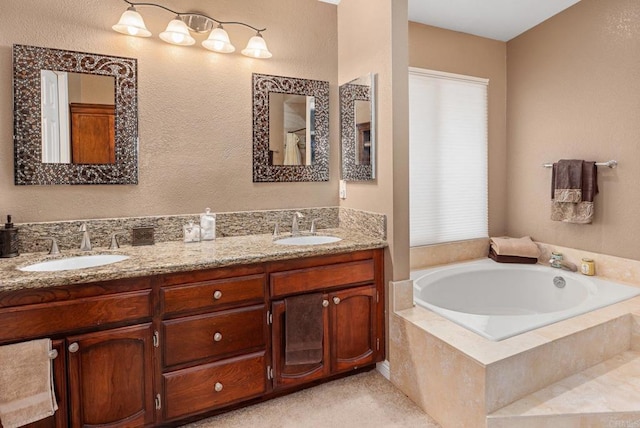 full bath with double vanity, plenty of natural light, a garden tub, and a sink