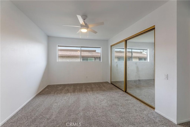 unfurnished bedroom featuring a closet, carpet floors, baseboards, and a ceiling fan