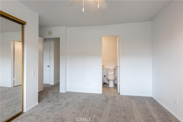 unfurnished bedroom with connected bathroom, carpet floors, and ceiling fan