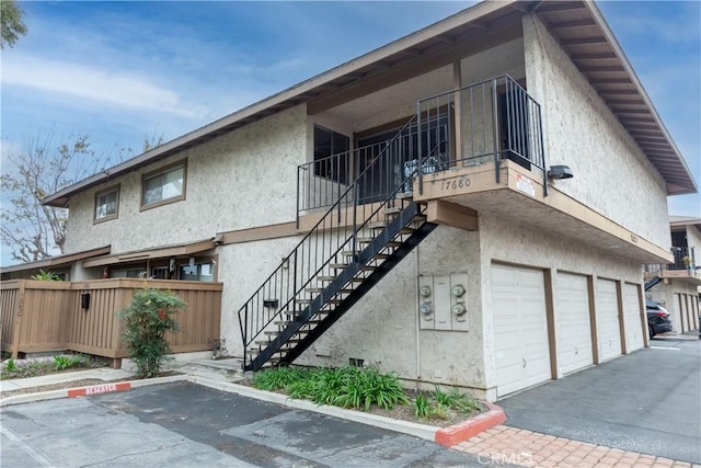 view of building exterior featuring stairway and an attached garage