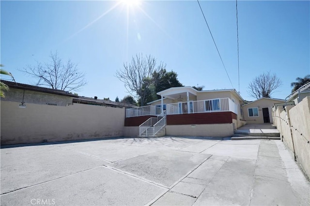 view of front of home featuring stairs, a patio area, fence, and a wooden deck