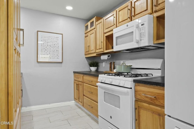 kitchen with white appliances, dark countertops, glass insert cabinets, and baseboards