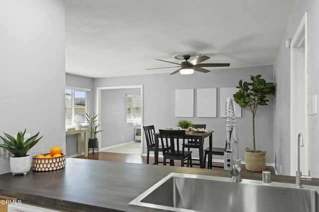 dining room with a ceiling fan, baseboards, and wood finished floors