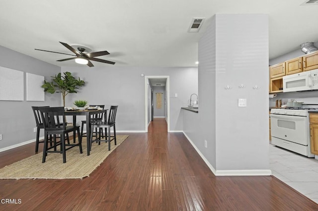 dining space featuring ceiling fan, wood finished floors, visible vents, and baseboards