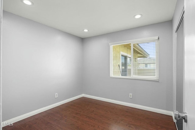 unfurnished room with dark wood-style floors, baseboards, and recessed lighting