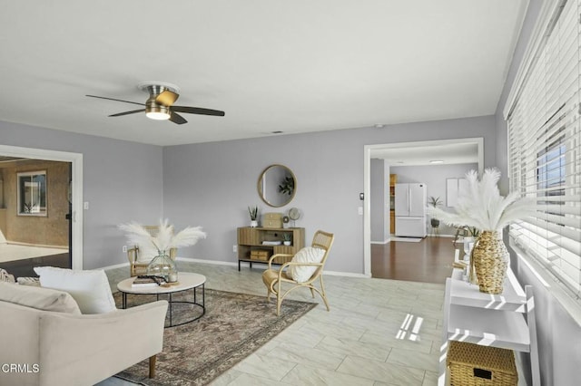 living room featuring marble finish floor, a ceiling fan, and baseboards