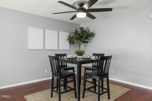 dining room featuring a ceiling fan, baseboards, and wood finished floors