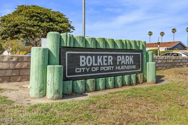 community / neighborhood sign featuring fence