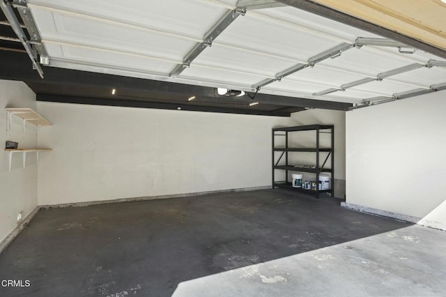 garage featuring a garage door opener and baseboards