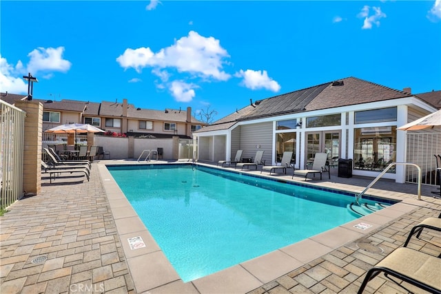 community pool featuring a patio and fence