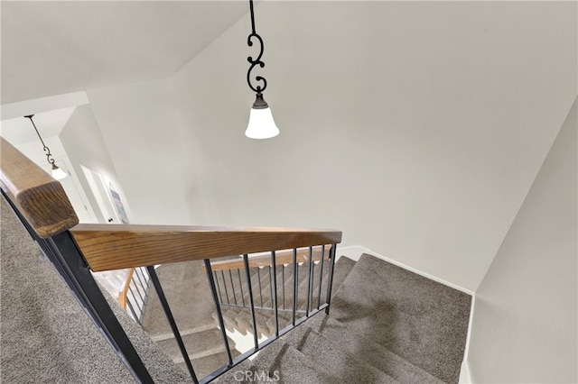 staircase featuring lofted ceiling and carpet flooring