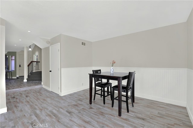 dining area featuring recessed lighting, wood finished floors, visible vents, stairway, and wainscoting