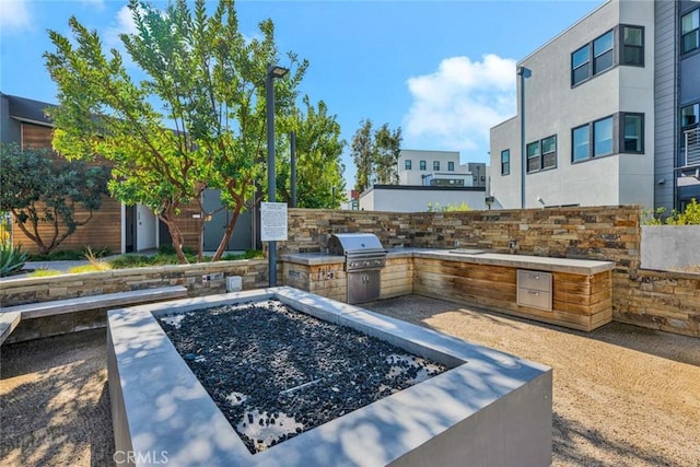 view of patio with exterior kitchen and a grill