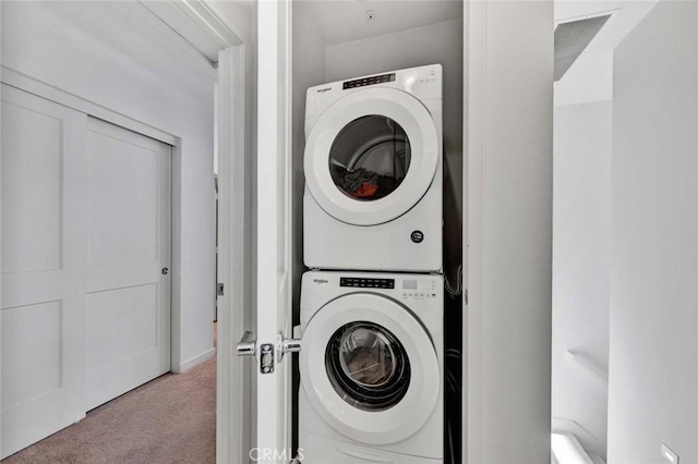 laundry room featuring carpet and stacked washer and clothes dryer