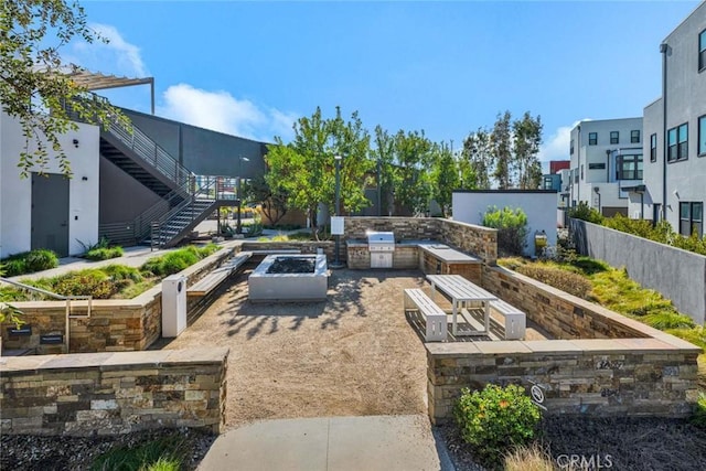 exterior space featuring stairway, area for grilling, grilling area, fence, and a garden