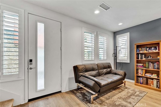 living area with baseboards, visible vents, wood finished floors, and recessed lighting